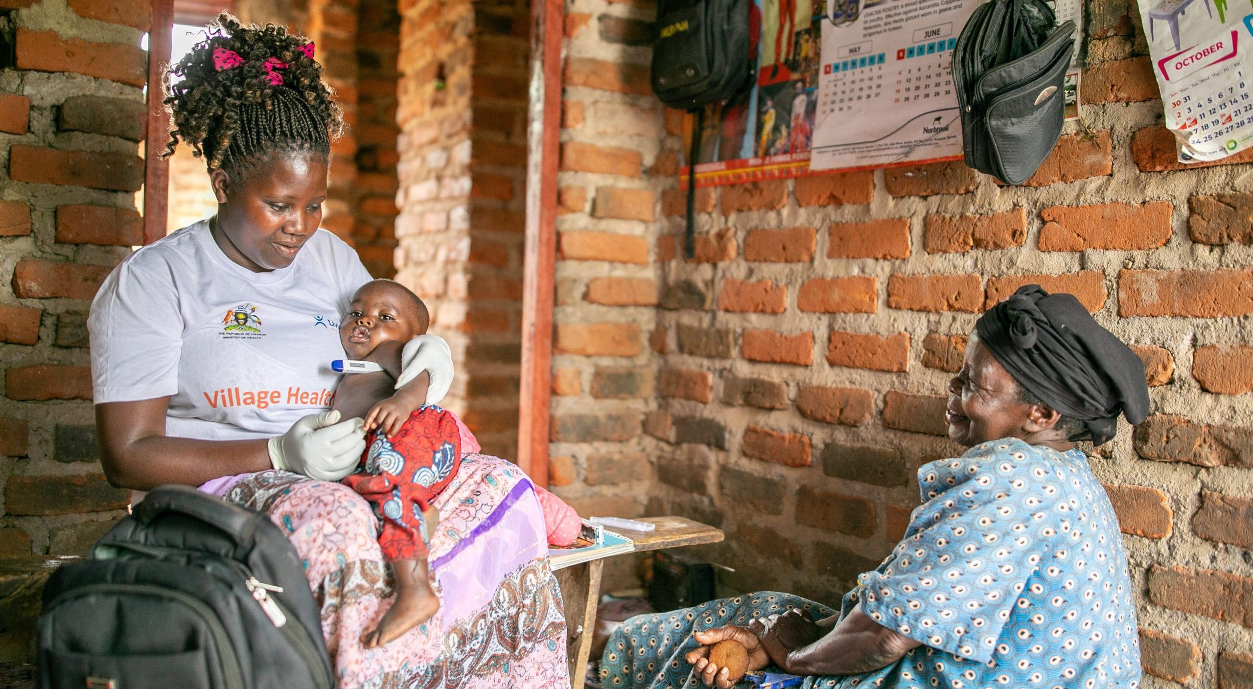 CHW Shadia tests a baby’s temperature in Masaka District, Uganda.