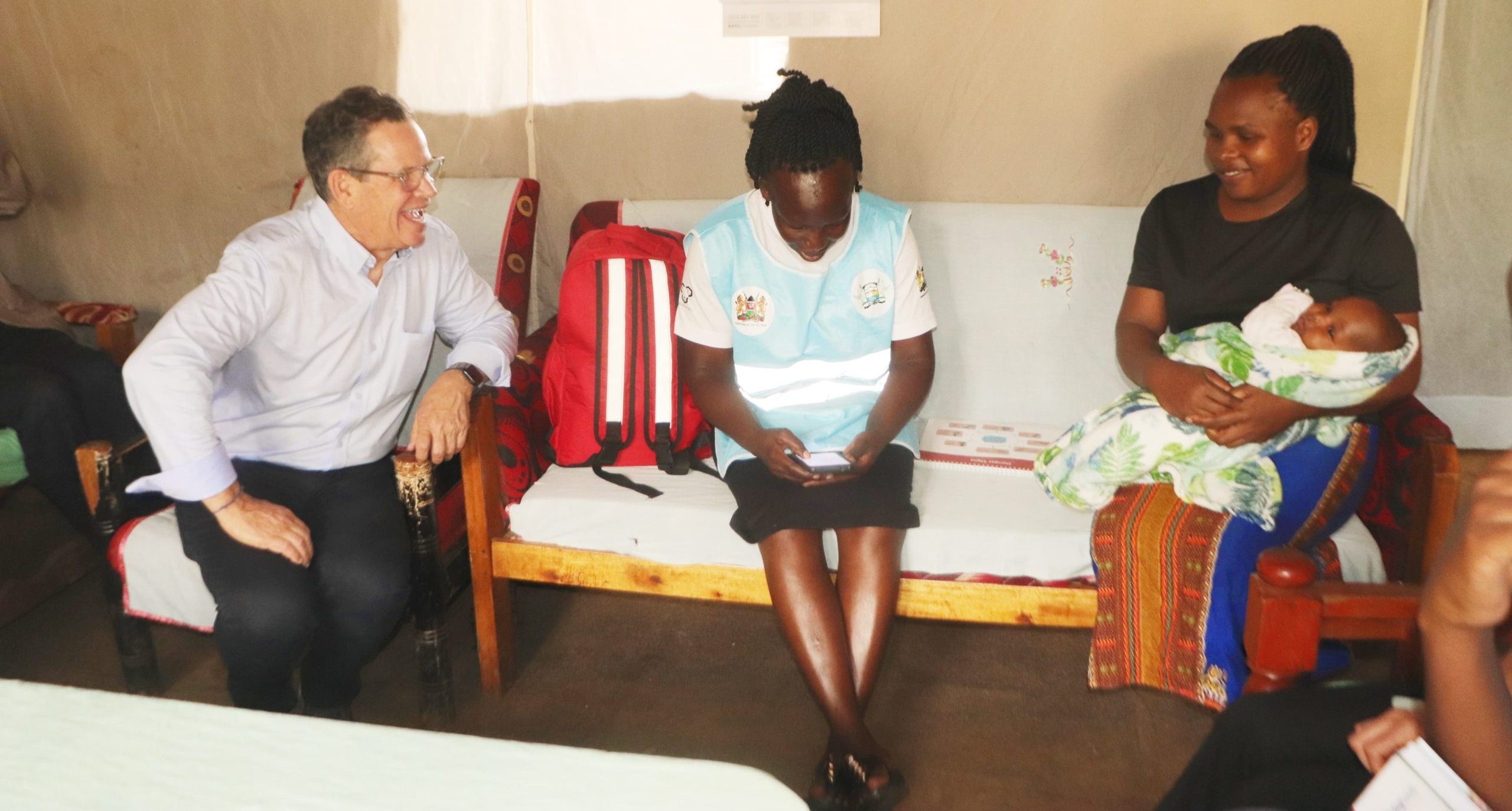 Board Chair Chuck Slaughter engaging with a client and a community health promoter.